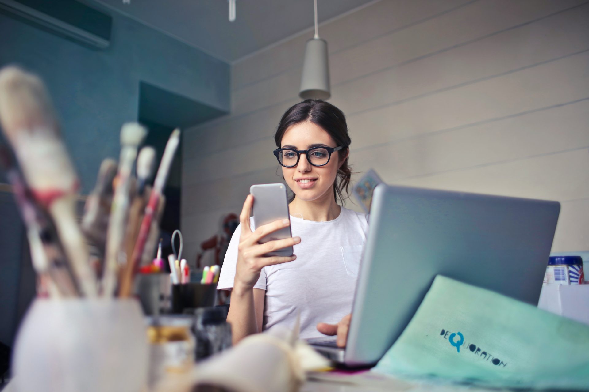 Creative professional using mobile and laptop simultaneously